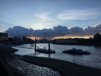 Boats moored in sea against sky during sunset