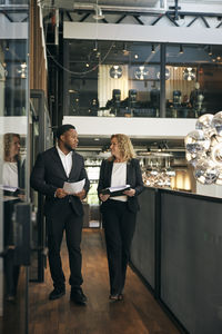 Side view of woman using mobile phone while standing in cafe