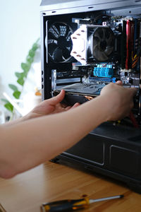 Man repairs a computer system unit, changes parts, video card and hard drive