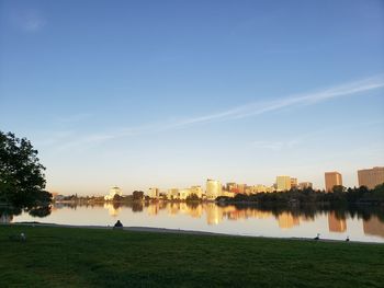 Scenic view of river by buildings against sky