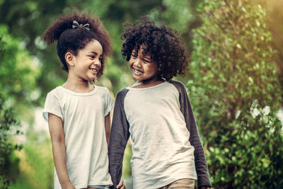 Happy friends standing against blurred background