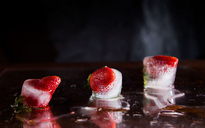 Close-up of strawberries on table against black background