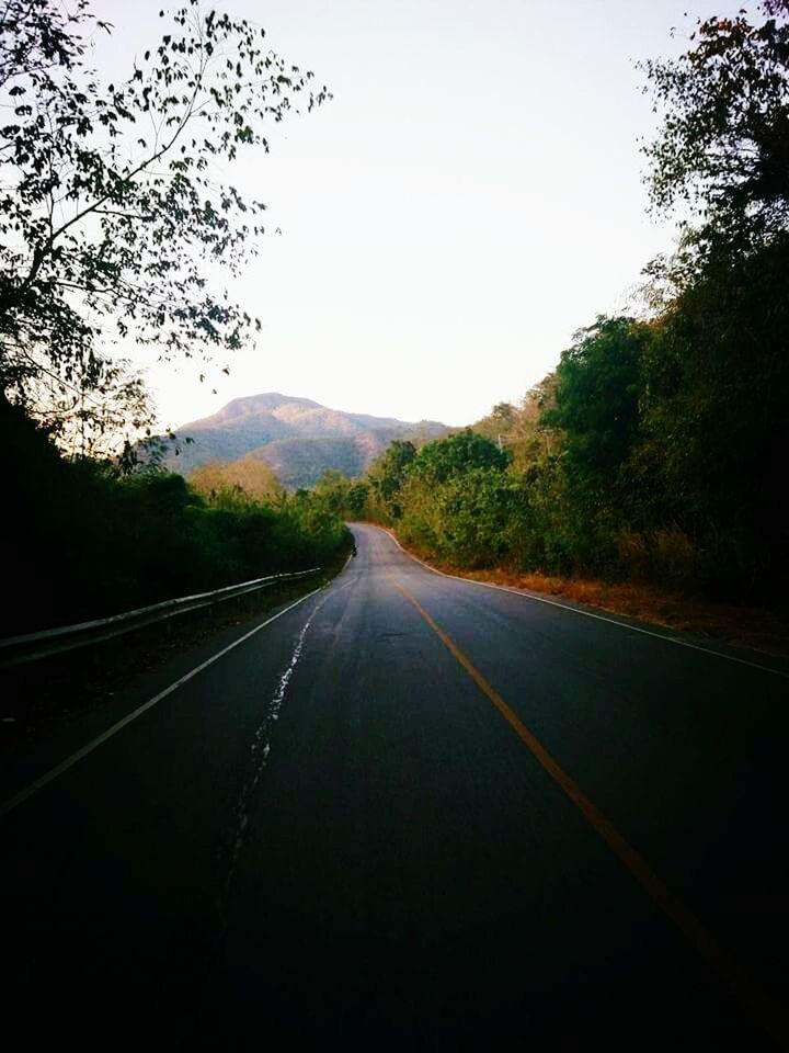 ROAD BY TREES ON MOUNTAIN AGAINST SKY