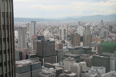 Aerial view of buildings in city against sky