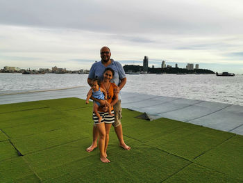 Family with cute baby enjoys the time by the sea