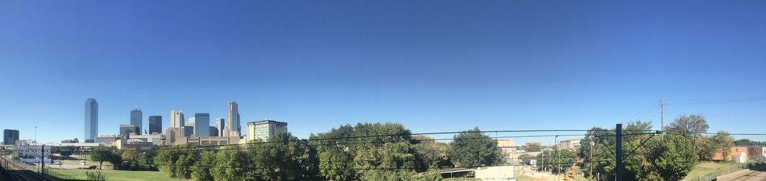 Panoramic shot of buildings against clear blue sky