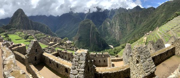 Panoramic view of old ruins against cloudy sky