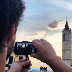 Cropped image of man photographing through smart phone