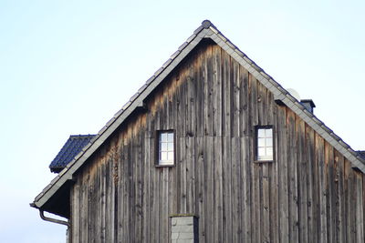 Low angle view of wooden house against clear sky