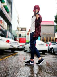 Full length of man standing on wet street