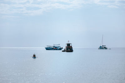 Sailboats sailing in sea against sky