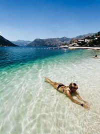 Women laying in the clear water on paradise beach 