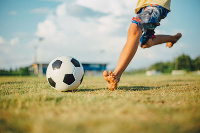 Boy playing soccer ball on grass