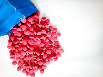 Directly above shot of red tablets over white background