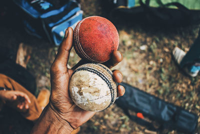 Close-up of hand holding cricket balls 