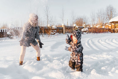 Full length of child playing in snow during winter