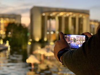 Midsection of man photographing in city