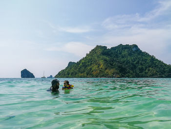 Father and daughter swimming in sea