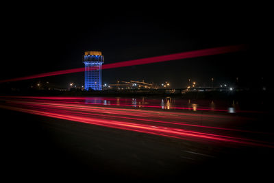 Light trails on road against sky at night