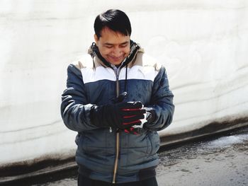 Mid adult man standing in snow