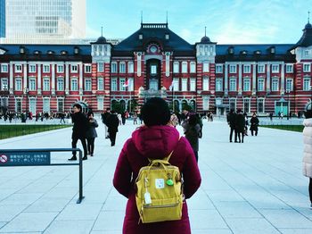 Rear view of people walking on street against buildings