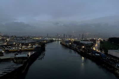 River amidst illuminated buildings in city at night