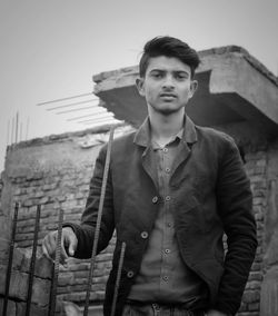 Portrait of young man standing at construction site