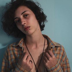 Portrait of young woman against wall