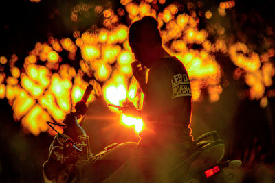 Rear view of man standing by bonfire