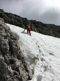 Low angle view of person on mountain against sky