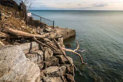 Retaining wall, pier with ducks, fallen tree, private property sign, fence running to waters edge