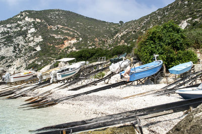 Boats moored on shore against sky