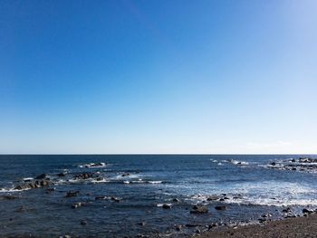 Scenic view of sea against clear blue sky