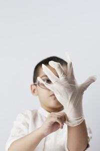 Midsection of boy holding hat against white background