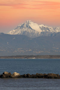 Scenic view of sea and snowcapped mountains against sky during sunset