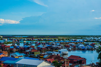 High angle view of townscape by sea against sky