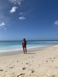 Full length of woman on beach against sky