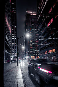 Illuminated city street and buildings at night