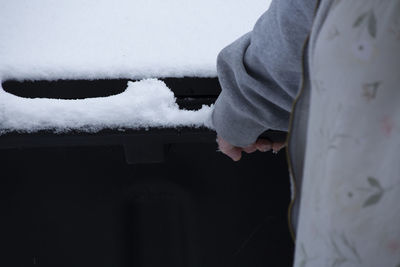 Low section of man standing on snow