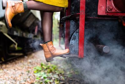 Low section of woman standing on stream train