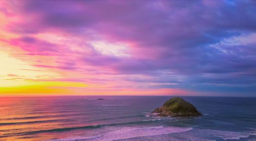 Scenic view of sea against dramatic sky during sunset