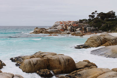 Scenic view of rocks on beach against sky