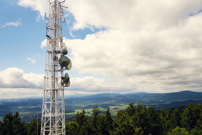 Communications tower against cloudy sky