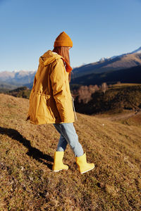 Rear view of woman walking on field