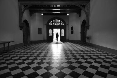 Rear view of woman walking in corridor of building