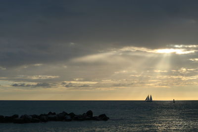 Scenic view of sea against cloudy sky during sunset