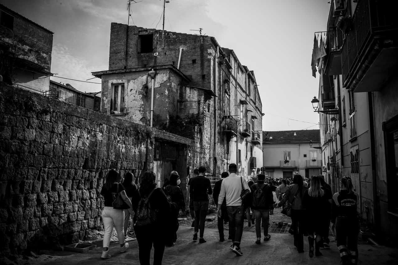 road, street, architecture, building exterior, built structure, city, urban area, group of people, monochrome, black, black and white, crowd, infrastructure, sky, monochrome photography, building, walking, men, alley, large group of people, adult, women, lifestyles, darkness, cityscape, city life, nature, white, residential district, night, city street, outdoors, snapshot