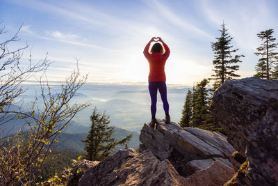 Full length of man standing on rock against sky