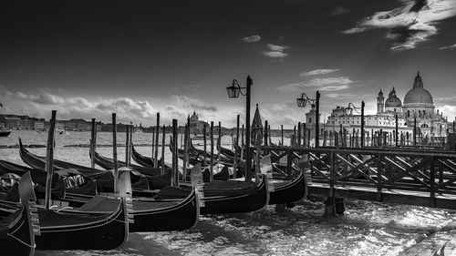 Boats moored at canal against sky