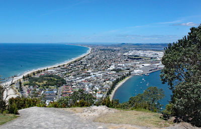 Aerial view of city by sea against sky